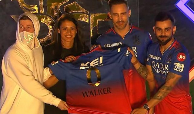 At the unbox event, Alan Walker receives the new RCB jersey from Kohli, Faf, and Smriti. 1 At the unbox event, Alan Walker receives the new RCB jersey from Kohli, Faf, and Smriti.